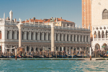 VENICE, ITALY - FEBRAURY 14, 2020: Library, St. Marco coloumn and coloumn of St. Theodor on St. Marco square and gondolas on water.