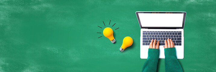 Person using a laptop computer and light bulbs