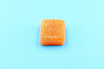 A square of jelly beans and sugar on a blue background