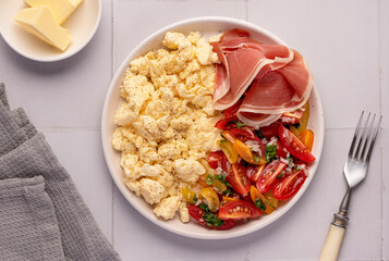 Food photography of scrambled eggs, breakfast, brunch, omelet, prosciutto, tomato, salad, butter