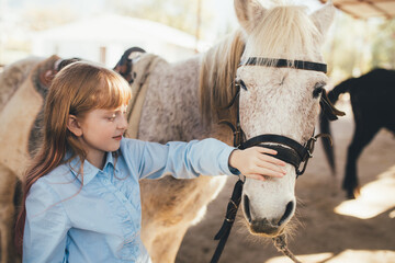 A young girl hugging a horse.