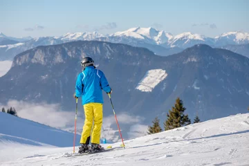 Fotobehang man and woman skiing and snowboarding in the mountains, ski resort © st.kolesnikov