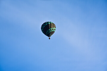Enjoying travelling with hot air balloon in the clear blue sunrise morning sky for family gathering and school holiday travel destination