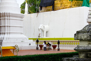 Praying woman in front of a Buddhist temple. Chiang Mai, Thailand