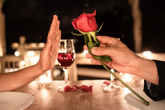 Woman refusing rejecting a rose from man. Relationship problem breakup. No second date. 