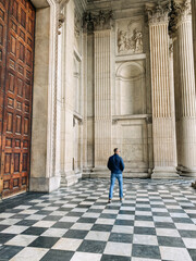 tourist man standing in the foyer of a big old building 