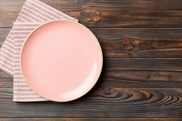 Top view on colored background empty round pink plate on tablecloth for food. Empty dish on napkin with space for your design - Powered by Adobe
