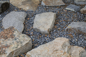 Stones on gravel bed garden architecture, pathway accessory. Rock texture for background. Backyard Garden Modern Design Landscaping.