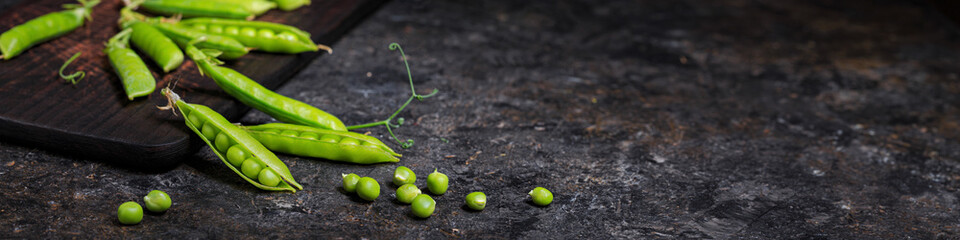 Rural still life, banner horizontal - view of the pea crop, selective focus, close-up on a dark background with space for text. The harvest concept