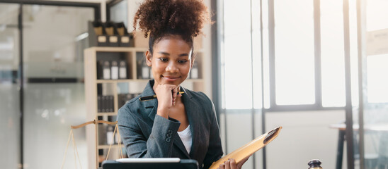 Portrait of successful attractive young business woman african american lawyer working at desk and holding contract paper after signing, legislation, law concept.