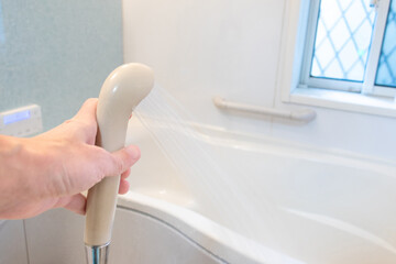 浴室で水を噴き出すシャワーヘッド