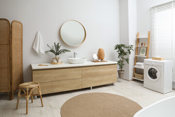 Modern bathroom interior with stylish mirror, eucalyptus branches and vessel sink