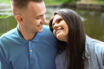Fototapeta premium Affectionate young couple sitting together in park, closeup