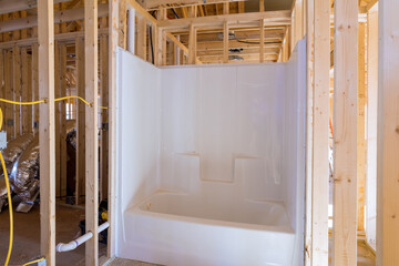 Unfinished bathroom under construction home with installed bathtub in new house