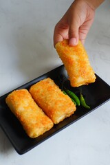 hand holding fried rissole mayonnaise 