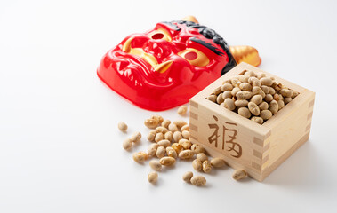 Beans for bean-throwing and masks of ogres placed on a white background.