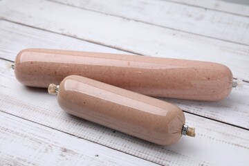 Delicious liver sausages on white wooden table