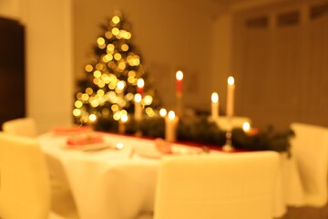 Blurred view of festive table setting and beautiful Christmas decor indoors. Interior design