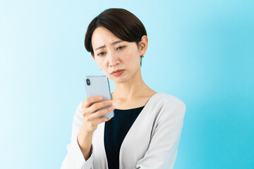Fototapeta premium スマートフォンを使う若い女性 ビジネスイメージ
