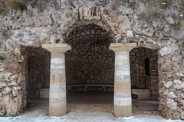 PYATIGORSK, RUSSIA - December, 2020: Old stone grotto of Diana with columns overgrown with green plants. The Dianas Grotto. Pyatigorsk landmarks The Northern Caucasus