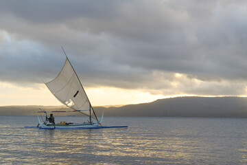 Fototapeta na wymiar Fisherman sailing at dawn. fisherman on a wooden boat at sunrise