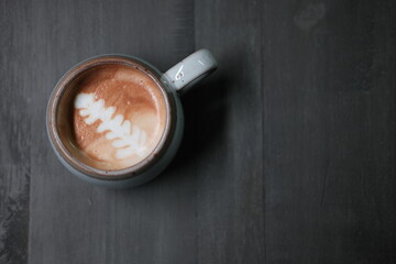 Cup of coffee on grey background. Place for texte. Top view of latte art coffee, on Gray abstract wooden background.