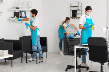 Young janitors with medical masks cleaning in office - obrazy, fototapety, plakaty