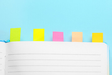 Open notebook with sticky notes on color background
