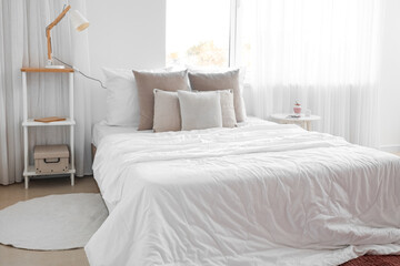 Interior of light bedroom with tables and and window
