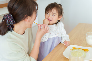 おやつを食べる女の子とお母さん