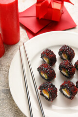 Plate with sushi rolls and chopsticks on grunge background, closeup. Valentine's Day celebration