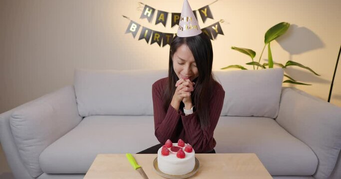 Woman make a wish for birthday at home