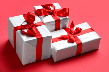 Gift boxes with beautiful bows on red background. Valentine's Day celebration