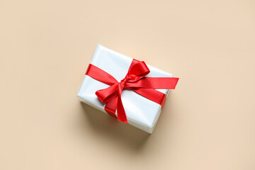 Gift box with beautiful bow on beige background. Valentine's Day celebration