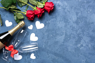 Bottle of wine, rose flowers, envelope and paper hearts on blue table. Valentine's Day celebration