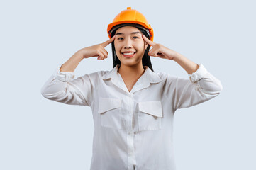 Young female engineer in helmet stand with thoughtful posture