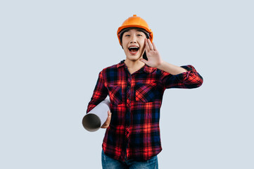 Young female engineer wearing a yellow safety helmet with Blueprints