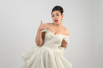 Fototapeta premium Young asian beautiful bride pose thumb up on white background