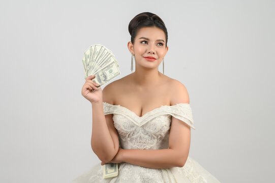 Young asian beautiful bride holding dollar bills in hand