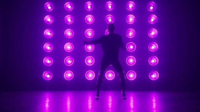 Alone female professional dancer performing a Modern hip hop or jazz funk dance in front colorful pink purple light wall during a Video Production in Studio Environment. Dance footage background RED