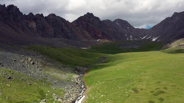 Aerial video of Altai river Yarlyamry. The stream is surrounded by alpine forb meadows.