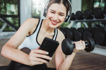 Fototapeta na wymiar Close up of woman using smartphone while workout in fitness gym.