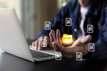 Businessman using computer laptop , holding folder and document icon software, searching and managing files online , database and document management system concept.