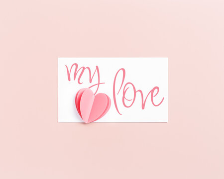 Pink cute cut heart and paper card with text my love, love note on pink background. Minimal trend flat lay, pastel color, mock up valentine Day card or wedding invitation. Romantic concept