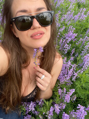 photo of a young woman in a summer field in flowers