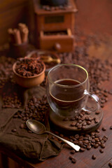 Cup glass of coffee with smoke and coffee beans on old wooden background