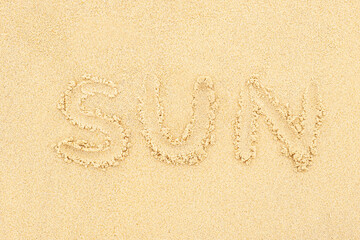 The inscription sun, made on the sand. The concept of summer beach holidays, vacation on the sea coast.
