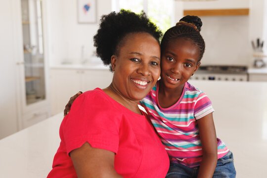 Portrait Of African American Grandmother And Granddaughter Embracing And Smiling, With Copy Space