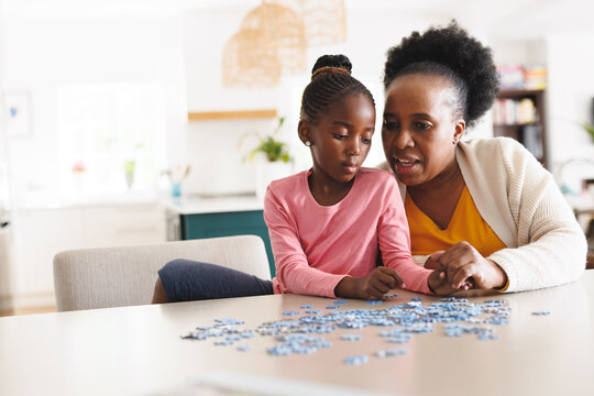 Happy African American Grandmother And Granddaughter Doing Puzzle