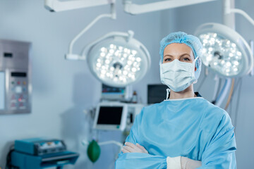 Portrait of caucasian female surgeon in an operating theatre, wearing face mask